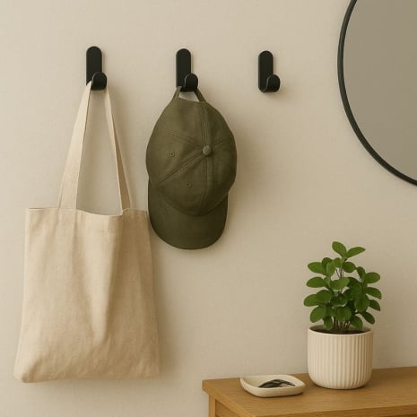 Patères murales noires fixées au mur sans perçage, servant de porte-manteau, porte-sac et porte-accessoires dans une entrée